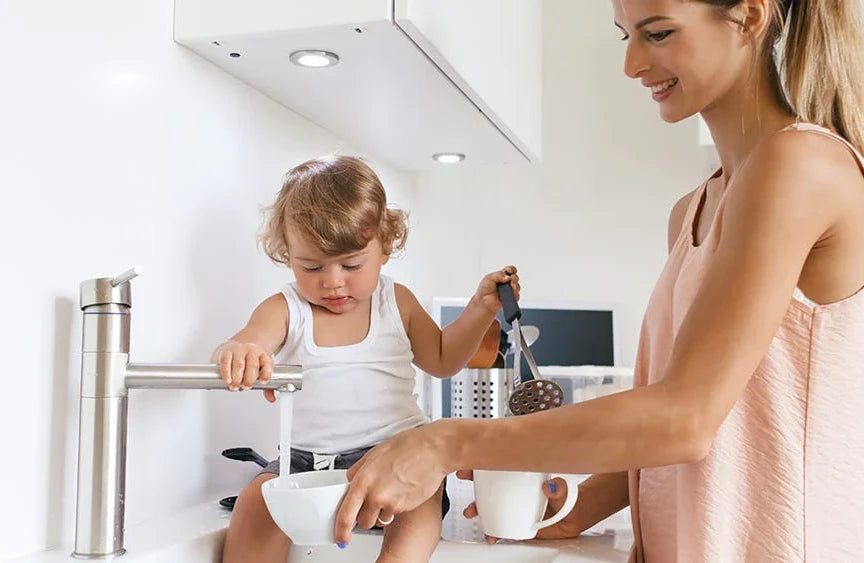 Mother and Child getting water from the sink