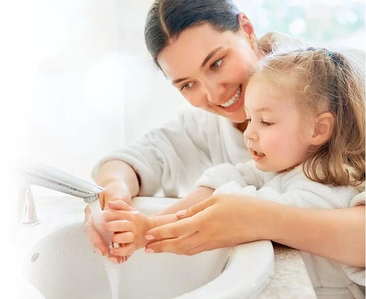 Mother and her Little Baby Girl washing their hands in the sink